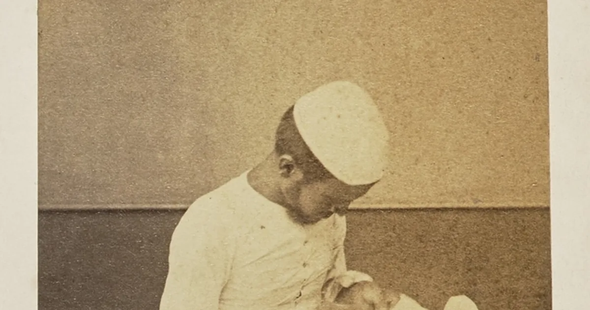 A tailor working on a garment with a measuring tape