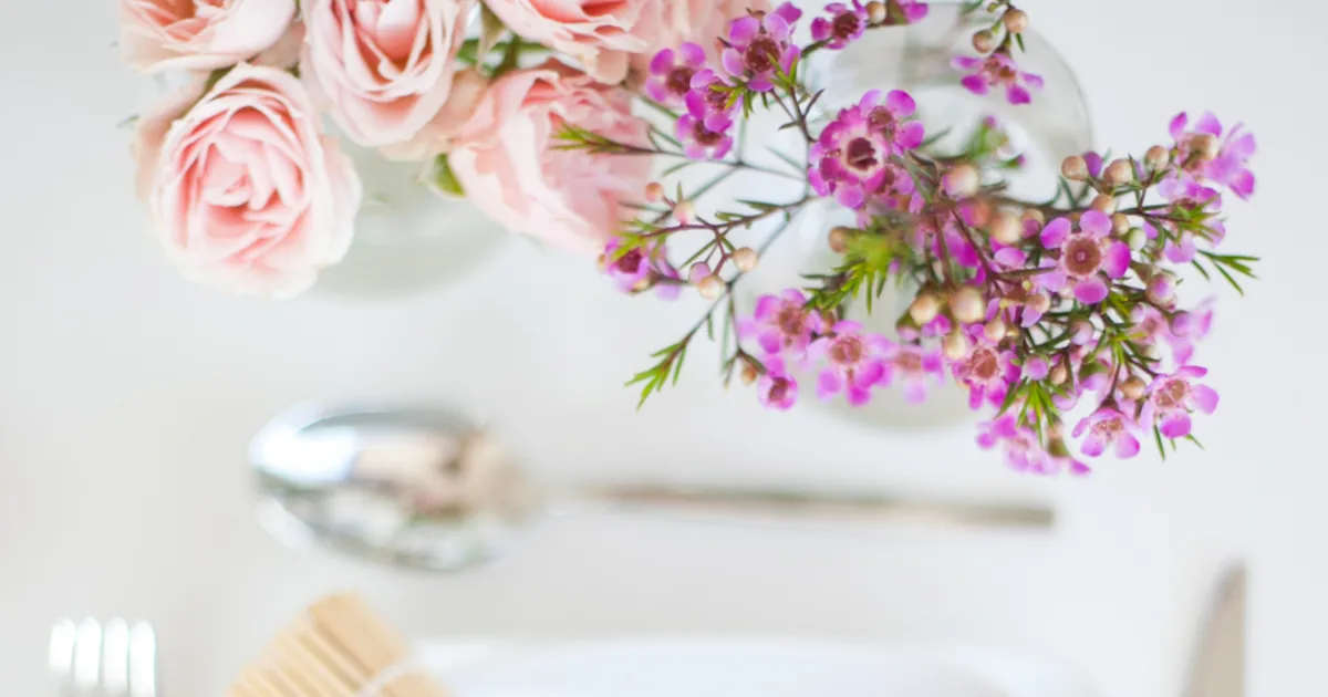 A neatly set dinner party table with plates and glassware