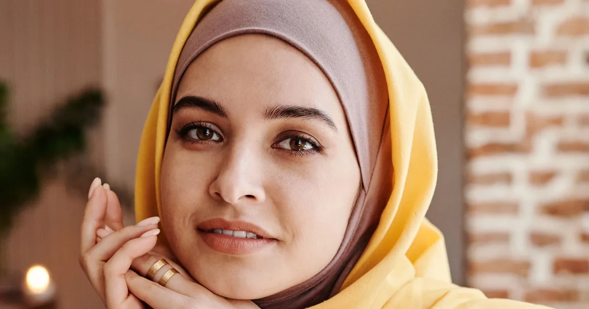Woman in a yellow hijab and olive shirt with clean drape
