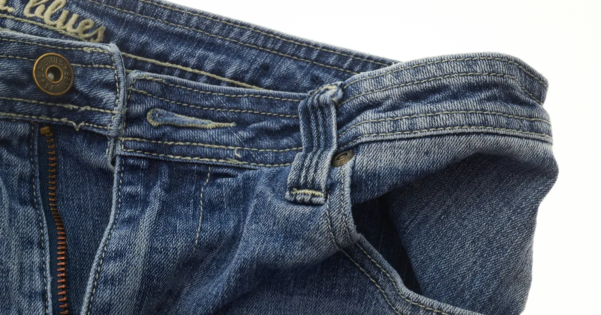 A pair of blue jeans folded showing the leg cut